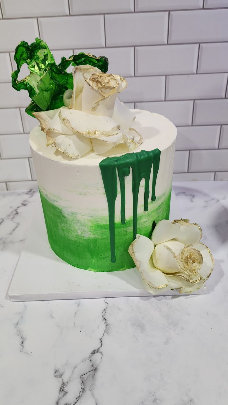 White and green ombre cake with a green drip and gold-edged white roses