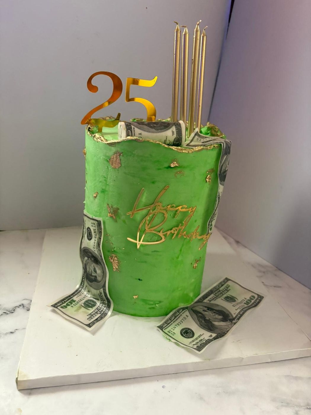 Green birthday cake wrapped in edible dollar bills with a gold 25 topper